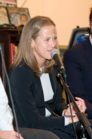 Wendy in profile speaks at a microphone